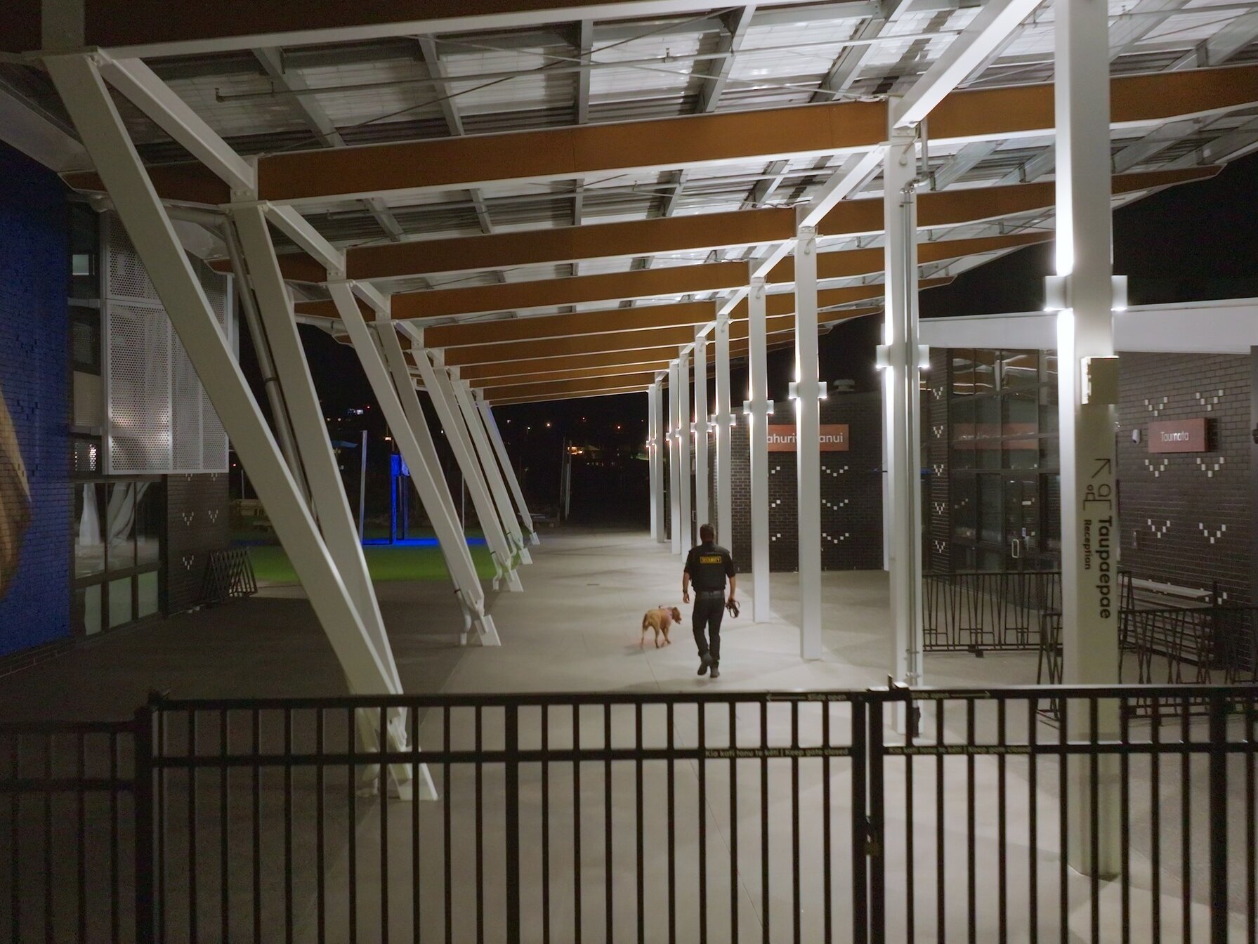 Watchdog night-time exterior check with portable lighting and high-visibility gear.